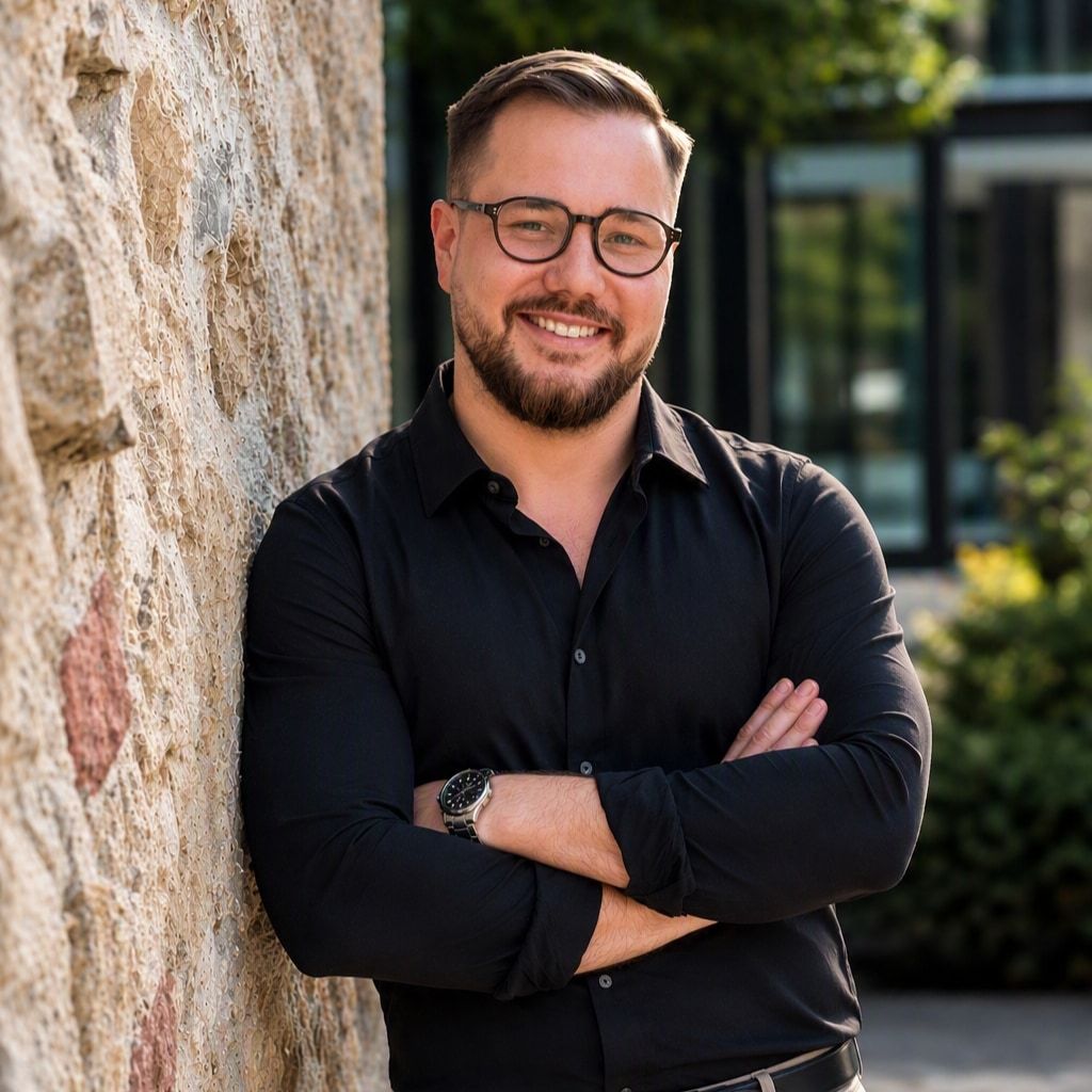 Daniel Schäfer, Porträtaufnahme mit verschränkten Armen an einer Steinwand